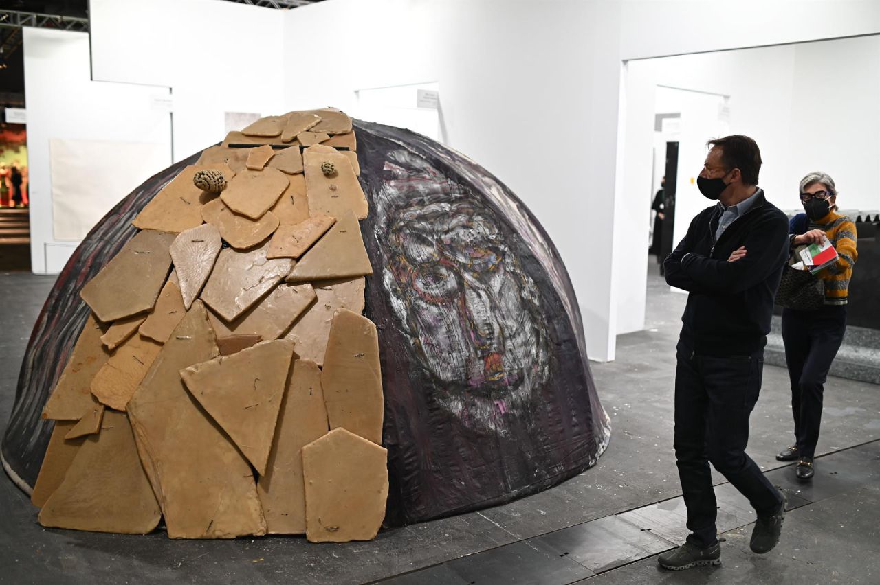  Varias personas pasan ante la obra de Mario Mertz- Susana Solano, de la galería de Turin, Giorgio Persano.