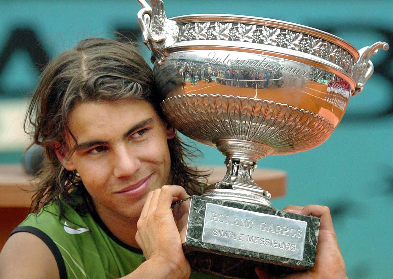 Un joven Rafa Nadal sonríe con su primer Roland Garros en 2005. El argentino Mariano Puerta no pudo frenar al español que ganó su primer Grand Slam por 6-7 (8), 6-3, 6-1 y 7-5.
