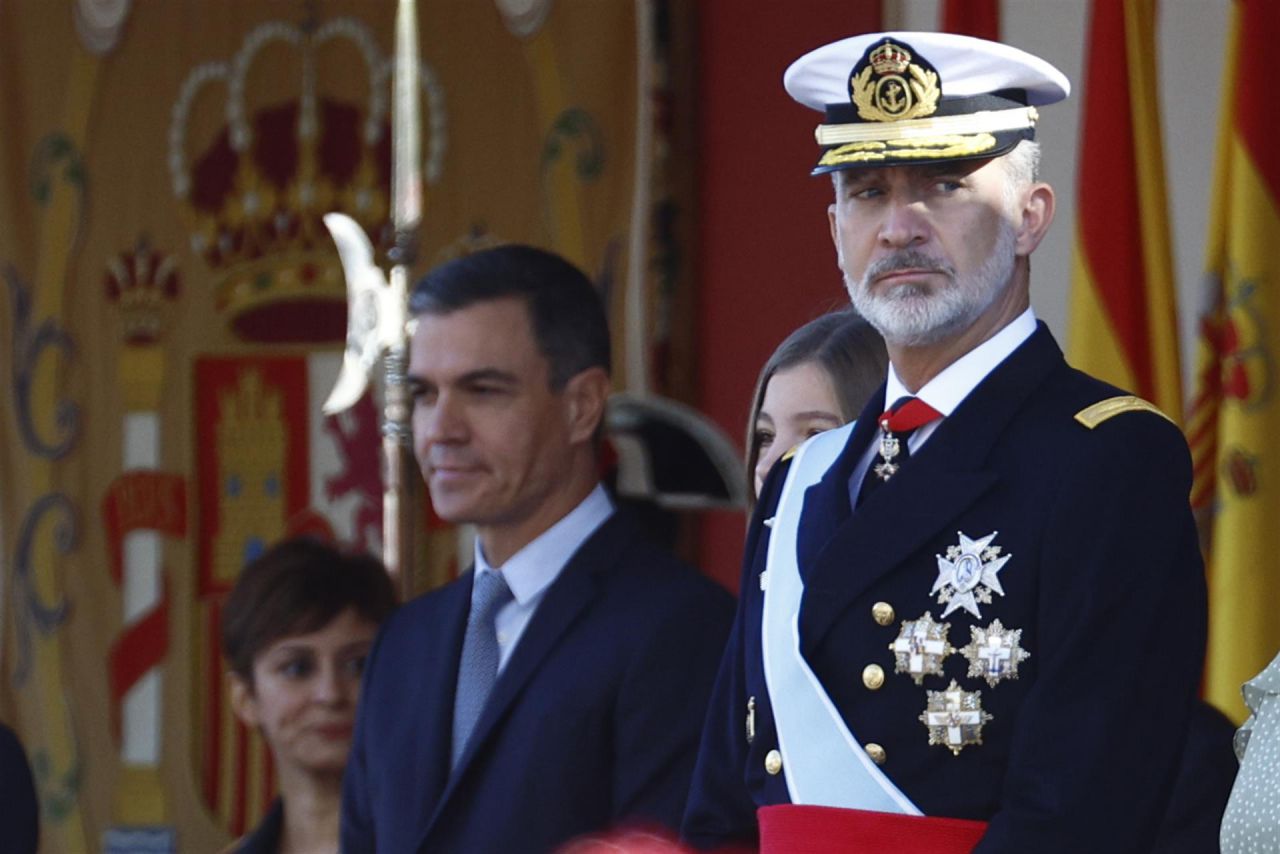 El Rey Felipe VI preside el desfile de la Fiesta Nacional, con el presidente del Gobierno en segundo plano.