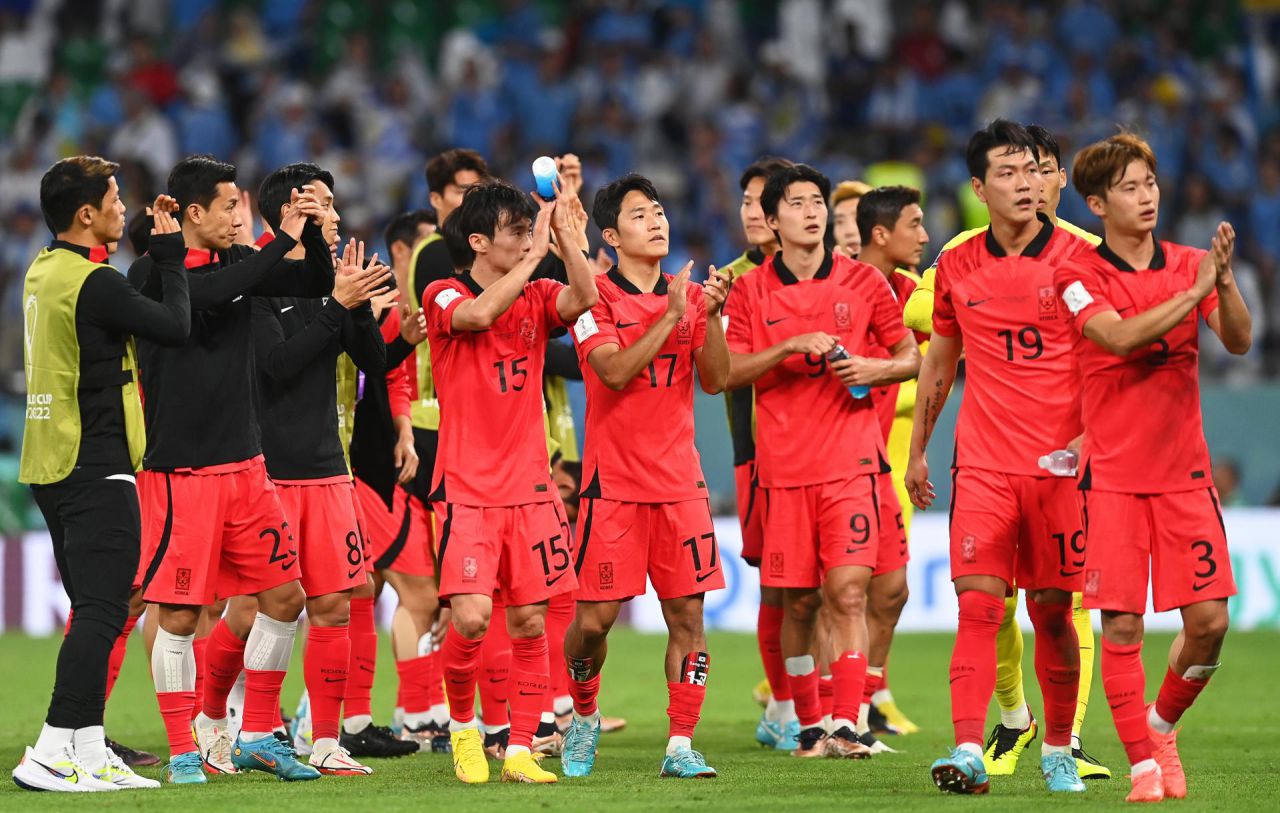 Los futbolistas de Corea del Sur saludan a su afición tras empatar ante Uruguay.