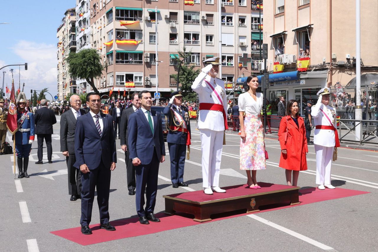 Los Reyes en el momento de la interpretación del Himno Nacional tras su llegada al lugar del desfile