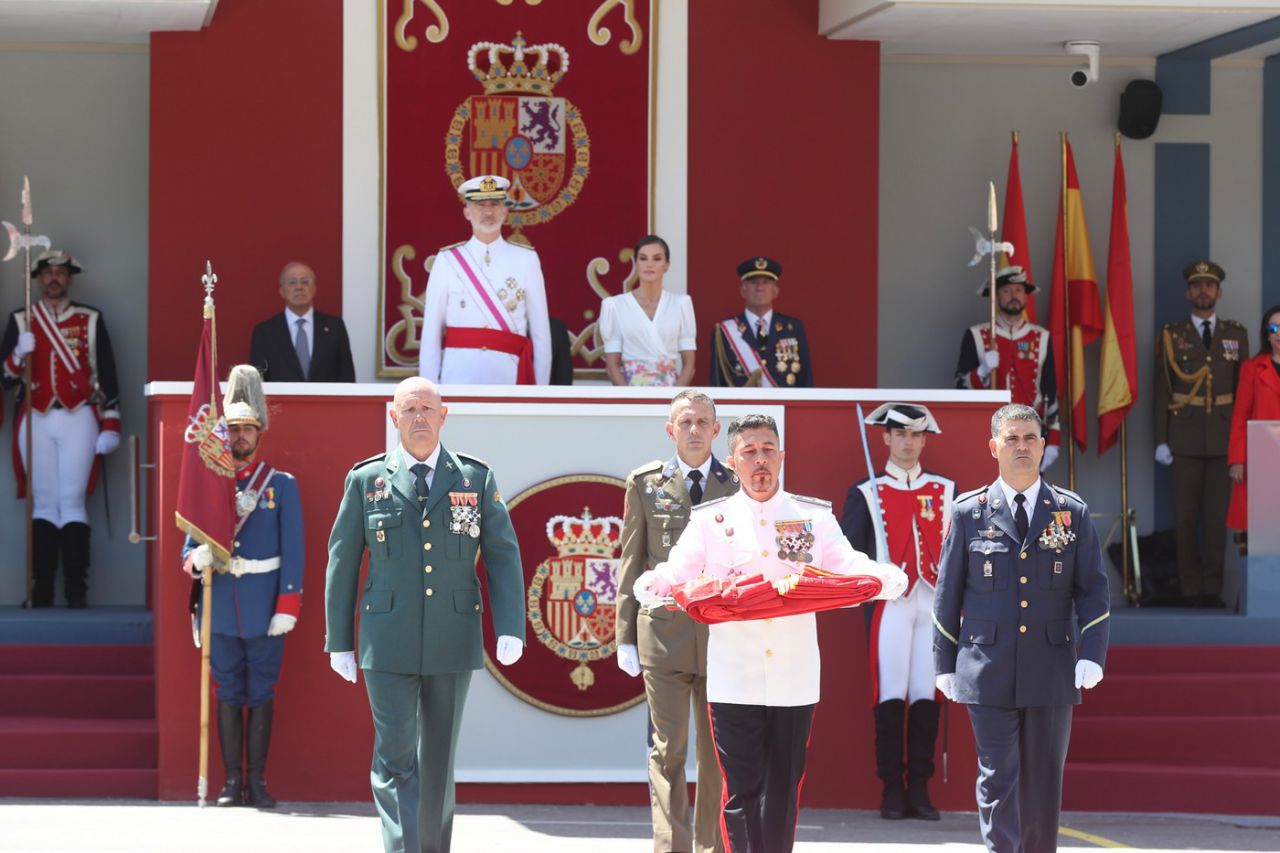 Momento en el que la Enseña Nacional portada por tres Guardias Reales y un Guardia Civil se traslada a la plataforma.