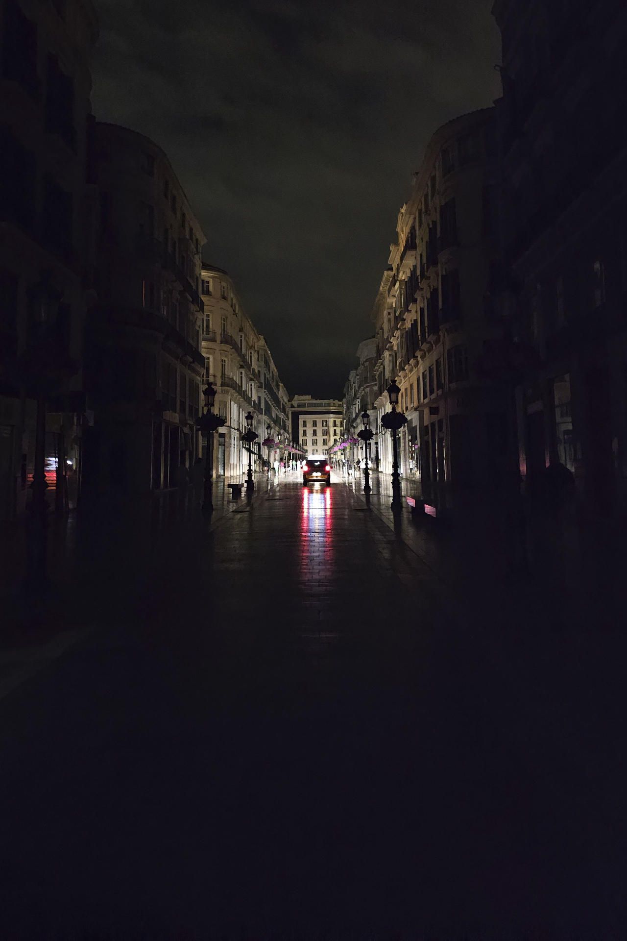 Vista de la céntrica calle Larios de Málaga, una de las más reconocidas de España, a oscuras durante la noche del lunes durante el apagón eléctrico. 