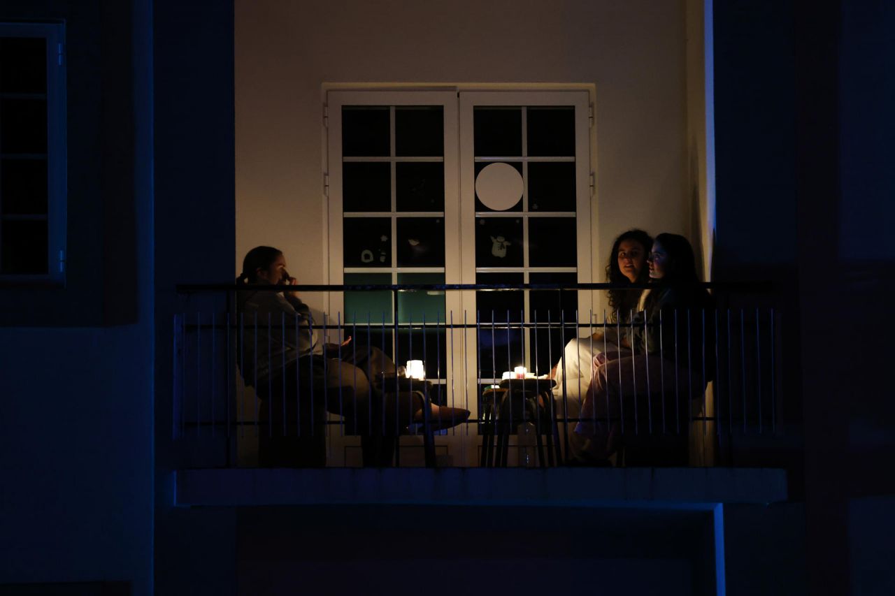 Personas se reúnen en un balcón durante un apagón este martes, en Santiago de Compostela (España). 