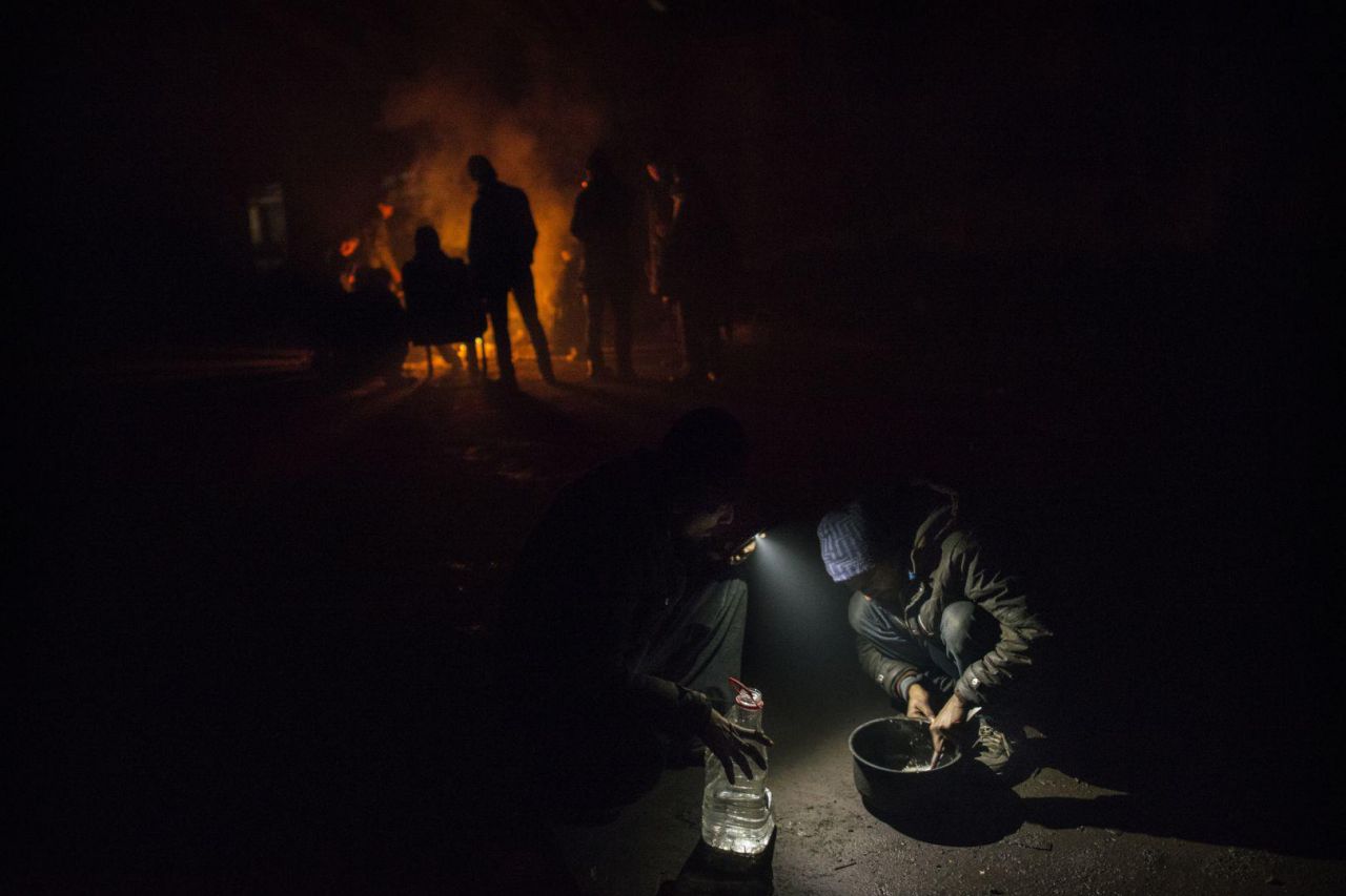 Los refugiados luchan contra las temperaturas heladas y cocinan en el suelo, en un edificio abandonado detrás de la estación de trenes en Belgrado, Serbia.