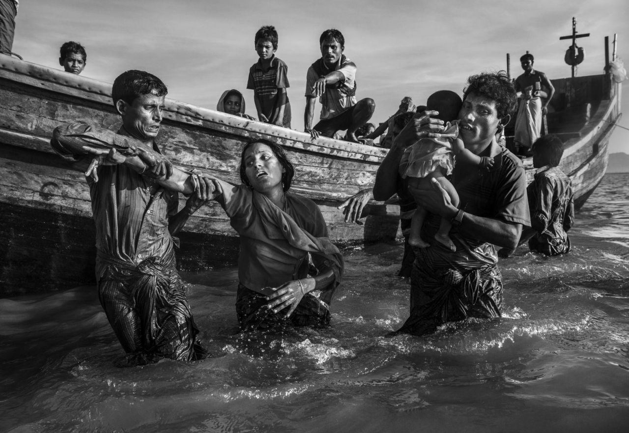 Un refugiado Rohingya es ayudado desde un bote cuando llega a Shah Porir Dwip, cerca de Cox's Bazar, Bangladesh.
