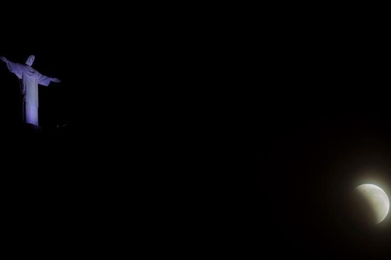 Vista de la luna con la estatua de Cristo Redentor durante el primer eclipse total del año, este domingo en la ciudad de Río de Janeiro.