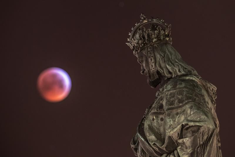 Súper luna de sangre vista desde Praga (República Checa) junto a la estatua de Carlos IV.