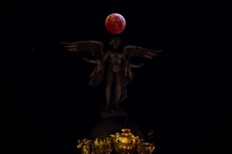 La luna junto a la escultura de la 'Victoria Alada', ubicada sobre la cúpula del madrileño Edificio Metrópolis.