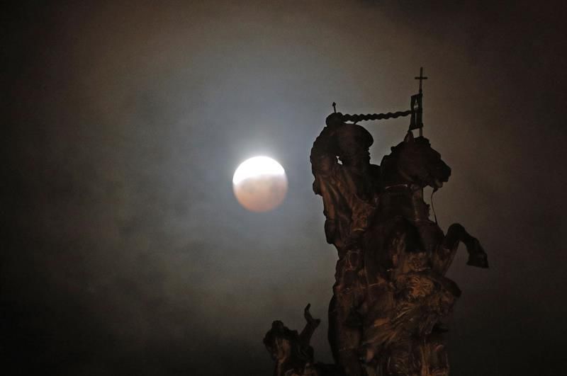 La luna llena durante la fase final del eclipse total, sobre una figura ecuestre del Apóstol Santiago en la Plaza del Obradoiro.