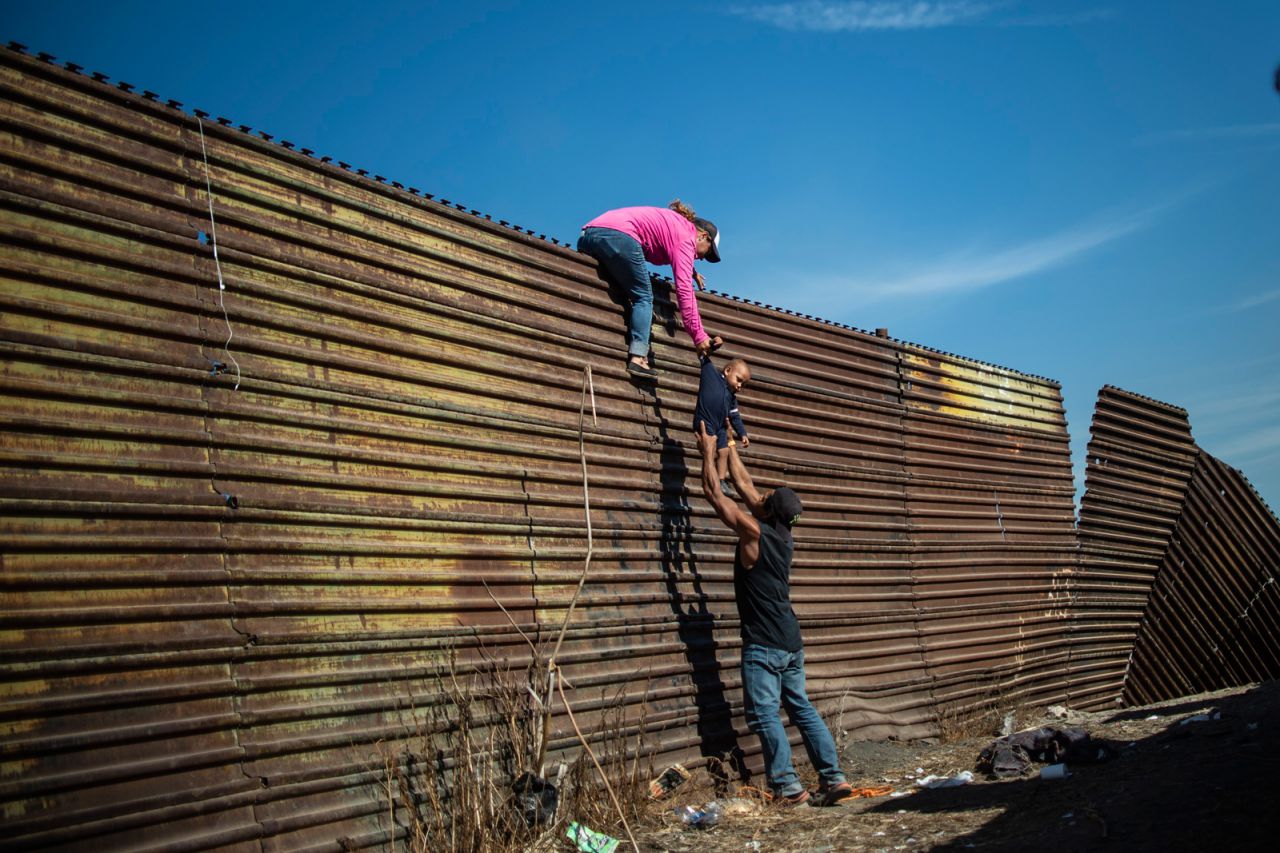Los migrantes centroamericanos trepan la frontera entre México y los Estados Unidos, cerca del cruce fronterizo de El Chaparral, Tijuana, Baja California, México, el 25 de noviembre de 2018.