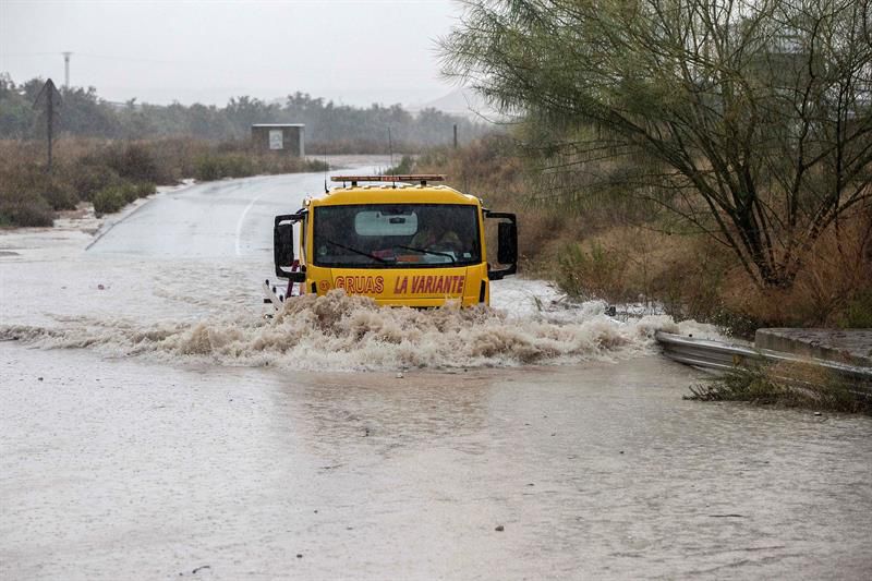 Una grúa pasa por la rambla de la Cañada Morcillo, en el polígono industrial de La Estrella en Molina de Segura.