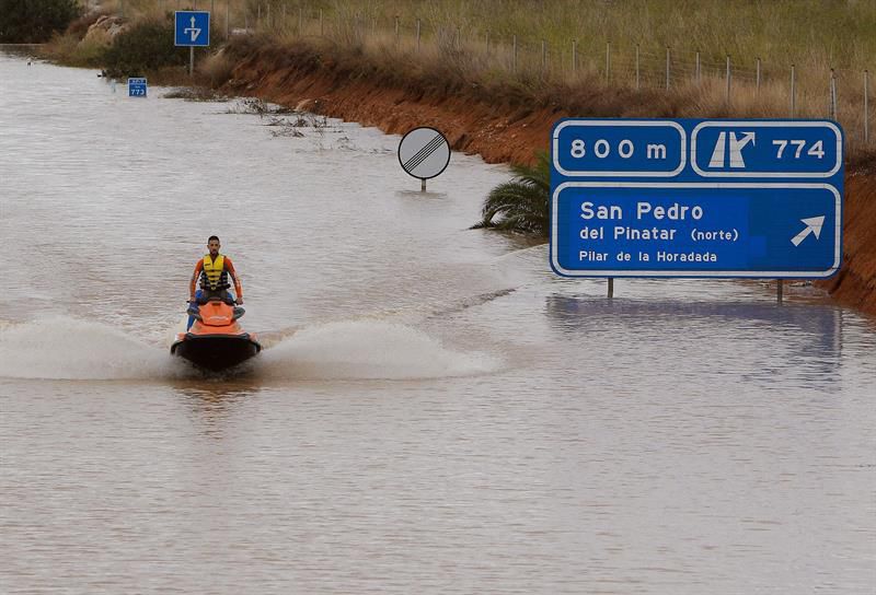 Un miembro de los servicios de rescate cruza en moto acuática la salida del túnel de la AP-7 a la altura del municipio alicantino Pilar de la Horadada.