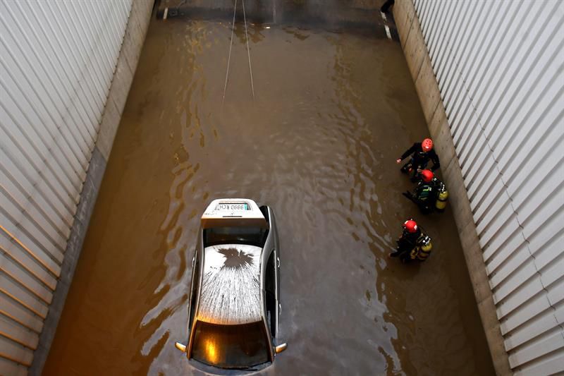 Bomberos trabajan en el rescate del cuerpo sin vida del hombre de mediana edad y origen subsahariano fallecido esta madrugada en un paso subterráneo inundado por la lluvia en Almería.