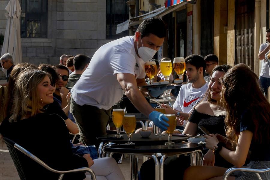 Un camarero sirve a sus clientes en un bar de la plaça de la Font de Tarragona