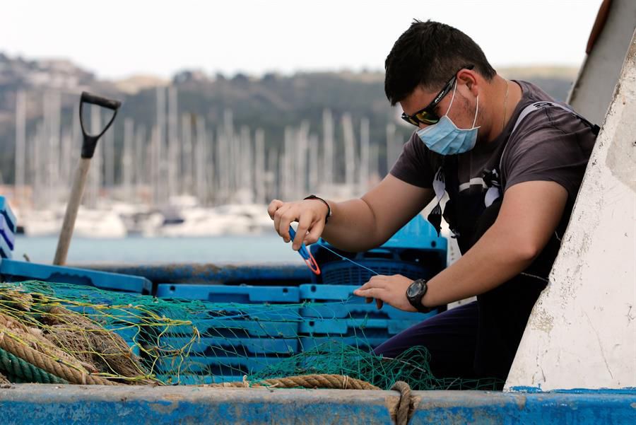 Un marinero repara una red en el puerto de Denia (Alicante) tras salir a faenar tras el parón decretado por el estado de alarma.