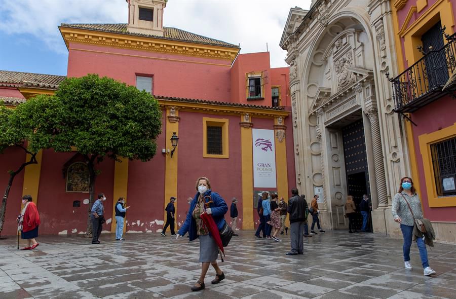 Varios fieles con mascarillas y guardando la distancia entran y salen del interior de la Basílica de Jesús del Gran Poder tras la misa celebrada hoy.