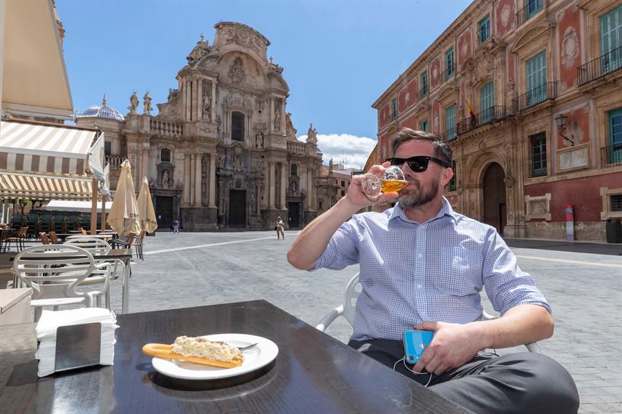 Un hombre toma una cerveza y una marinera, tapa típica de Murcia, en una terraza de la Plaza de Belluga.