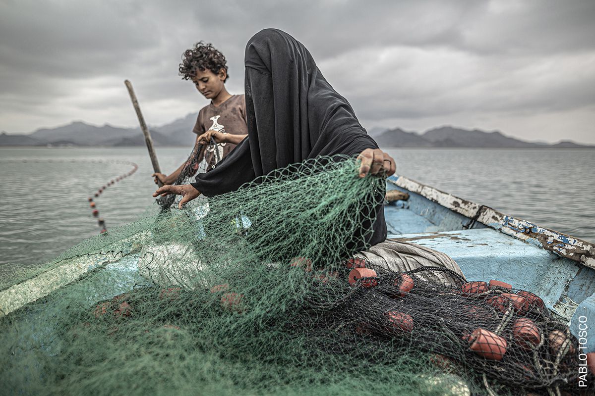 Fatima y su hijo preparan una red de pesca en un barco en la bahía de Khor Omeira, Yemen, el 12 de febrero.