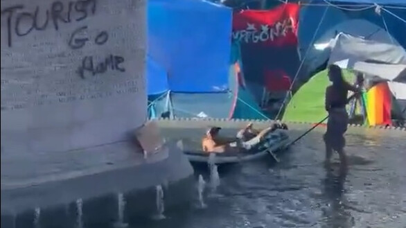Como si fuera su piscina: así se bañan los acampados de Sol en la fuente de Carlos III