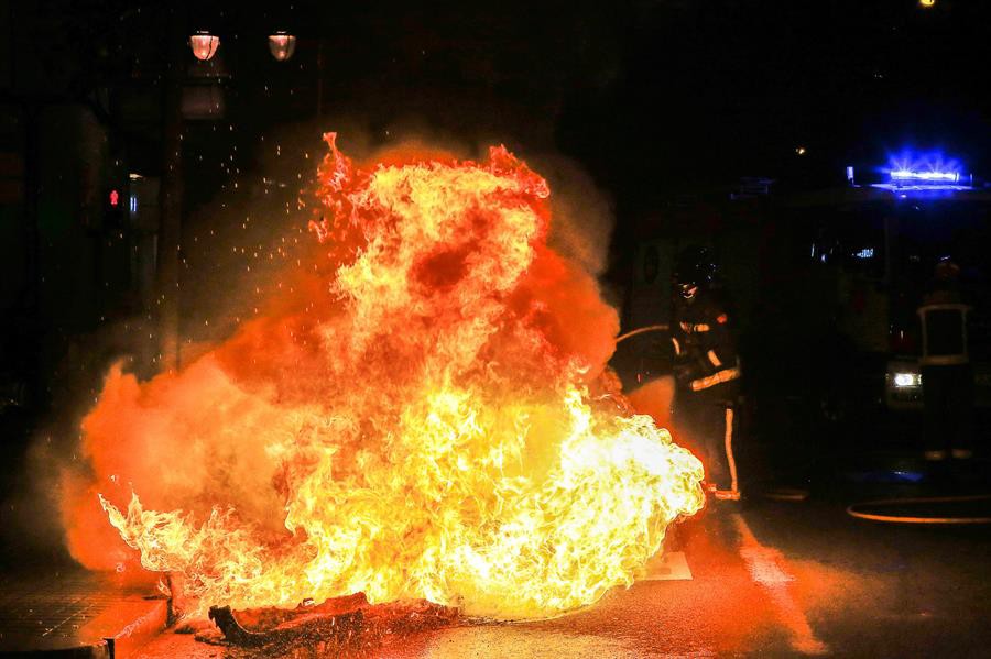 Los bomberos intenta apagar un contenedor que arde en el barrio de Grácia | EFE