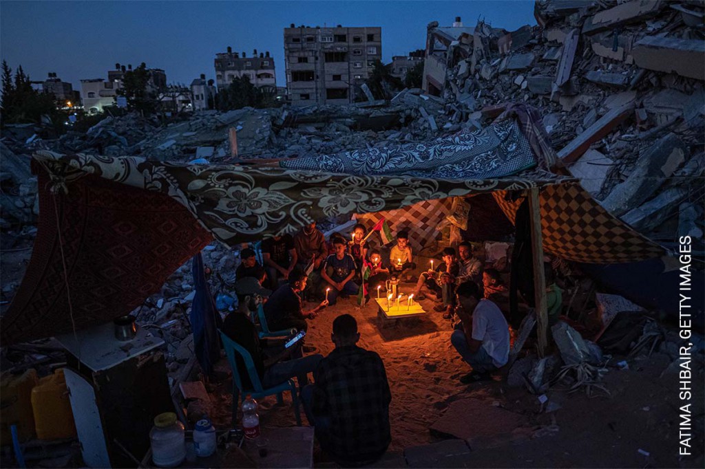 'Niños palestinos en Gaza' (© Fatima Shbair, Getty Images): Unos niños palestinos se reúnen con velas en Beit Lahia, Gaza, Palestina, el 25 de mayo de 2021, después de una protesta protagonizada por los jóvenes del barrio en contra de los ataques en la franja de Gaza, durante un frágil alto el fuego que tuvo lugar tras un enfrentamiento de 11 días entre Hamas e Israel.