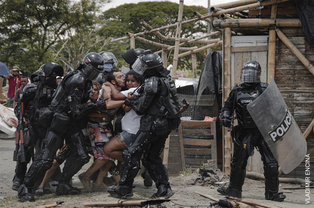 'Desalojo de la comunidad de San Isidro' (© Vladimir Encina): agentes de policía arrestan a un hombre a pesar de la resistencia de su esposa y demás familiares, durante los desalojos en la comunidad de San Isidro, Puerto Caldas, Risaralda, Colombia, el 6 de marzo de 2021.