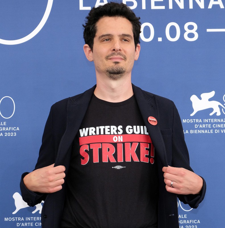 El director y presidente del jurado 'Venezia 80' Damien Chazelle posa con una camiseta en apoyo a la huelga de guionistas.