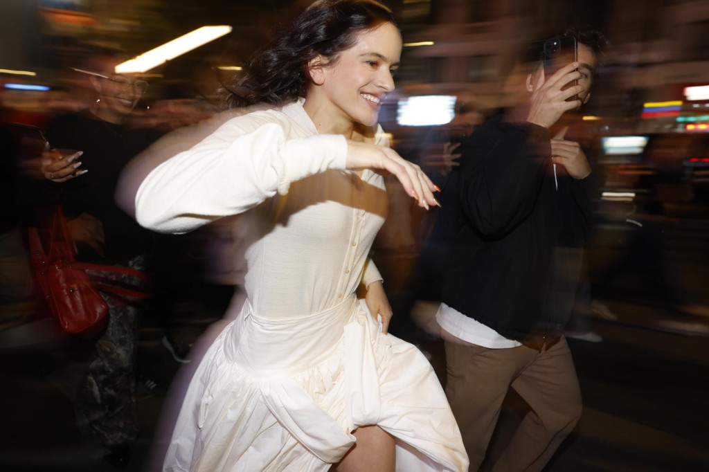 La cantante Rosalía corriendo por la Gran Vía de Madrid tras su aparición sorpresa para el anuncio de su nuevo disco 'Lux'. Foto: Efe