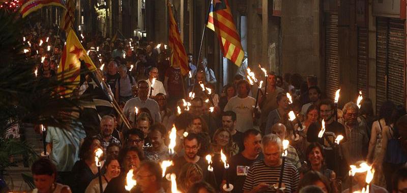 Simpatizantes de Esquerra Republicana de Catalunya se dirigen esta noche con antorchas a la Fossar de les Moreres, en Barcelona, para participar en la Vigilia de la Diada organizada por ERC-Barcelona Vella.