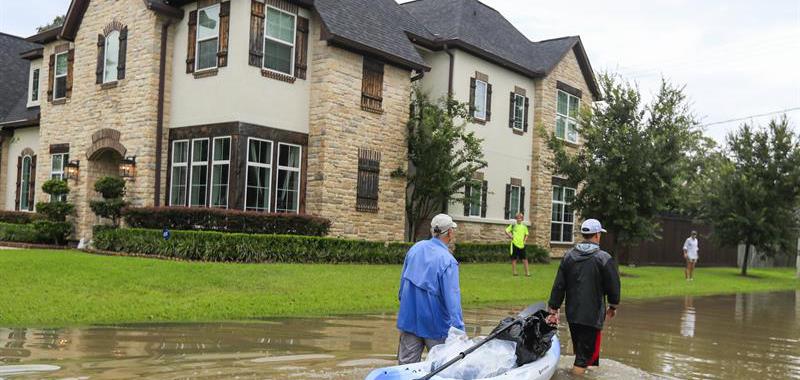Residentes de Houston transportan pertenencias en un bote.