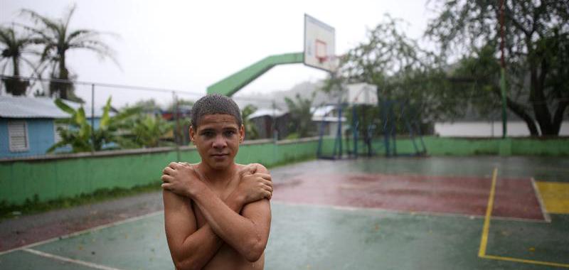Un niño permanece bajo la lluvia en Santo Domingo (República Dominicana).