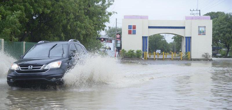 Un vehículo pasa por una calle inundada en Villa Vásquez, provincia de Monti Cristi (República Dominicana).