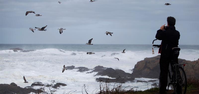 Una persona fotografía las olas producidas por el temporal en la ciudad de A Coruña.
