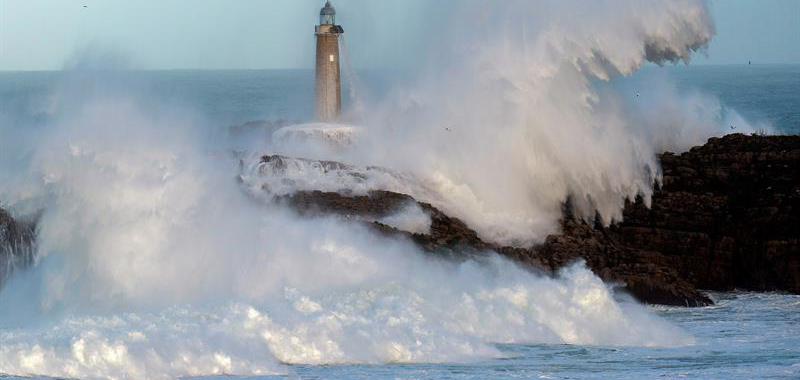 Una gran ola rompe esta tarde contra el faro de la Isla de Mouro en Santander.