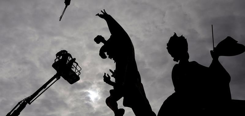 Unos operarios trabajan sobre una grua en el montaje de los remates superiores de uno de los más de 700 monumentos falleros que arderán la noche de San José.