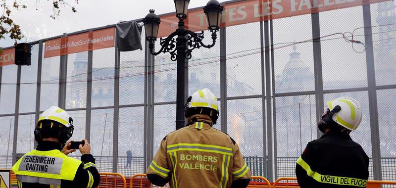 Un bombero alemán (i), uno valenciano y uno italiano (d), contemplan el disparo de la última Máscleta.