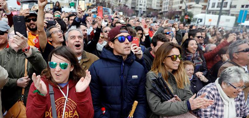 Asistentes al disparo de la última Máscleta oficial de las Fallas 2018 disparada hoy en la plaza del Ayuntamiento reaccionan al finalizar la misma. 