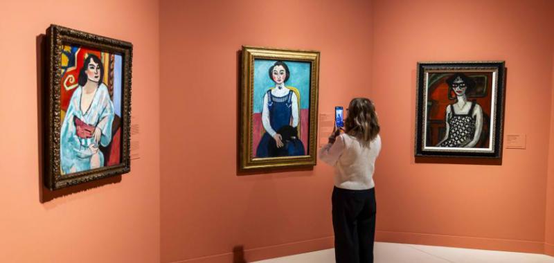 Una mujer fotografía la obra Marguerite au chat noir, de Henri Matisse, en CaixaForum Madrid.© Fundación "la Caixa"