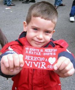 Un niño muestra una pegatina de Derecho a Vivir.