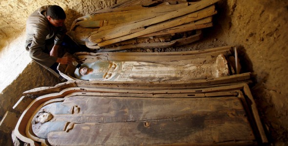 Un arqueólogo egipcio limpia los féretros de madera que contienen dos momias cubiertas con un trapo de lino, en la pirámide Illahun de la localidad egipcia de Faiyum. Efe