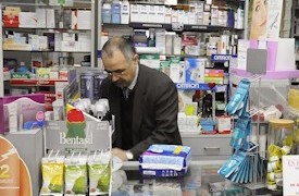 Un farmacéutico tras el mostrador en su oficina de farmacia