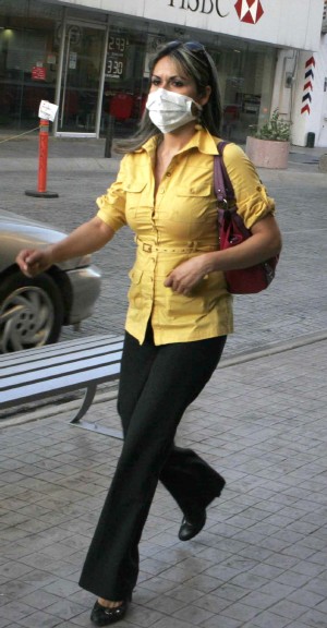 Una mujer pasea con mascarilla ante el peligro de contagio de la gripe (Efe)