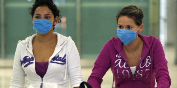 Dos mujeres con mascarillas para evitar el contagio de la gripe porcina (Efe)
