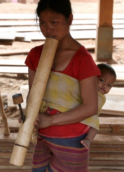 Una mujer y su bebé de la tribu Katu fuma en pipa de bambú en su poblado, donde viven gracias a una plantación de cafe, en la meseta Bolaven, al sur de Laos, el 18 de marzo de 2009. Las plantaciones de café en Laos surgieron en el siglo XX durante la colonización francesa. EFE/Barbara Walton