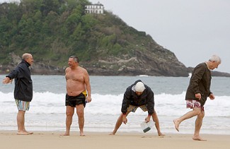 Un grupo de jubilados hace ejercicio en la Playa de la Concha.