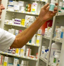 Un farmacéutico coge un medicamento.