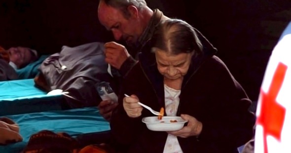 Dos víctimas del terremoto reciben una ración de comida en un centro de acogida instalado en L'Aquila. Efe