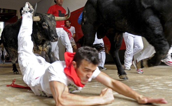 Un mozo cae ante los toros de la ganadería extremeña de Jandilla en el callejón que da acceso a la plaza de toros de Pamplona durante el último encierro de los Sanfermines 2010. EFE/Villar López