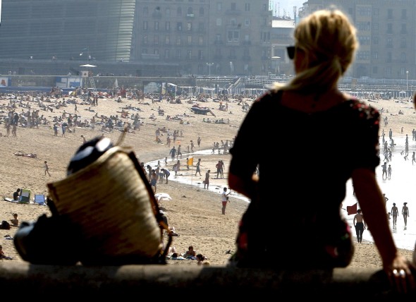 Una mujer observa la playa de La Zurriola de San Sebastián, donde los cielos despejados y las altas temperaturas han invitado a numerosas personas a darse un chapuzón. Efe